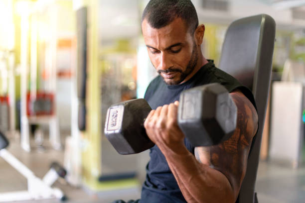 istock Strong handsome sport man doing biceps exercise in the gym 1188265548