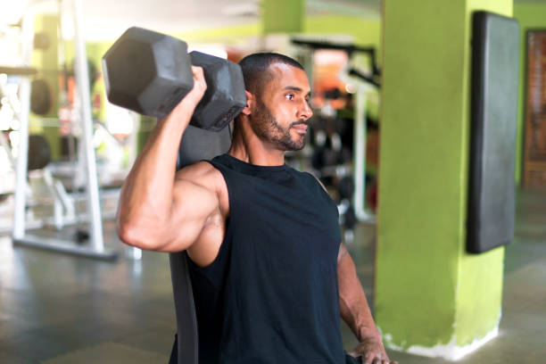 istock Strong handsome sport man doing shoulder exercise in the gym 1188265590