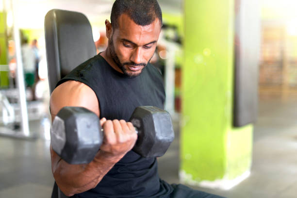 istock Strong handsome sport man doing biceps exercise in the gym 1188265642