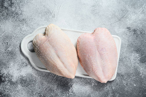 Raw chicken Breasts, fresh fillets with skin. Organic farm bird. Gray background Raw chicken Breasts, fresh fillets with skin. Organic farm bird. Gray background. turkey breast stock pictures, royalty-free photos & images