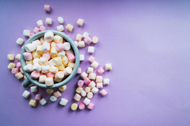 istock Hot chocolate with colorful marshmallows on purple background. Top view. Copy space. 1188279240