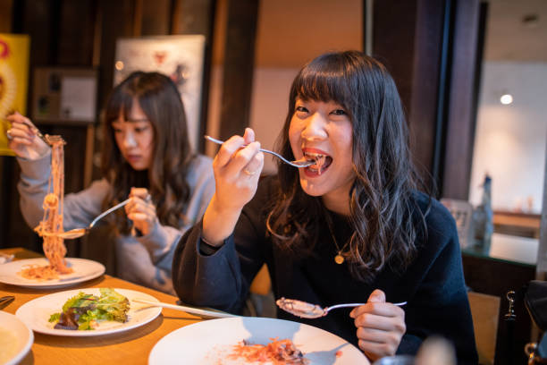 istock Young women eating pasta in cafe for lunch 1188284779