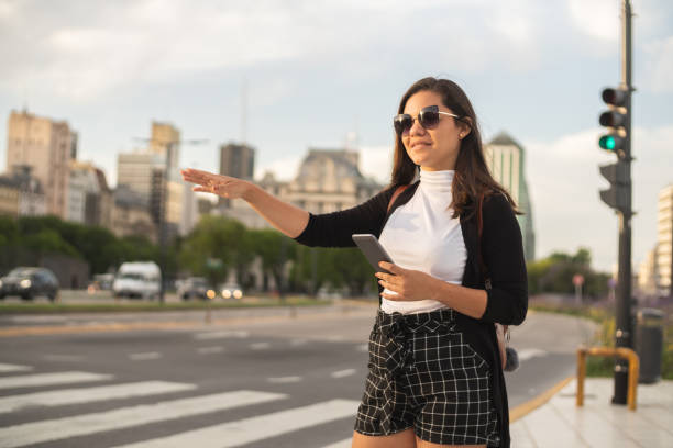 mujer que toma taxi desde su aplicación móvil en buenos aires - taxi buenos aires people city fotografías e imágenes de stock