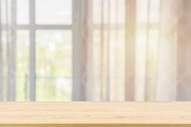 istock Empty wood table top with window curtain abstract blur background for product display 1188287808