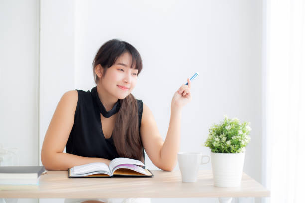 istock Beautiful asian woman writer smiling thinking idea and writing on notebook or diary with happy on desk office, lifestyle of asia girl is success, female planning working, education and business concept. 1188294122