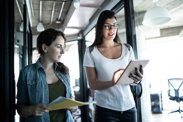 istock Coworkers walking and using tablet in office corridor 1188294710
