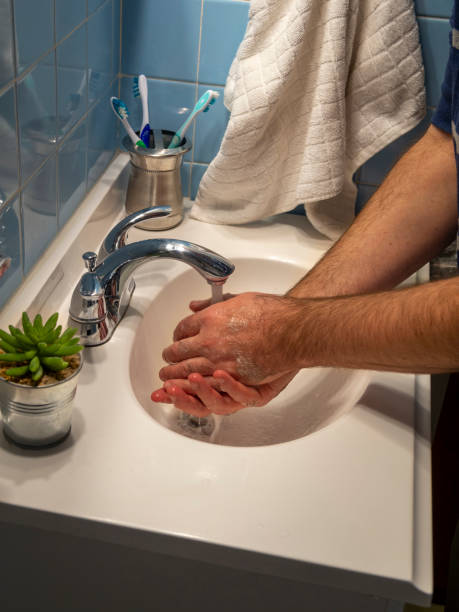 Washing hands in bathroom sink stock photo