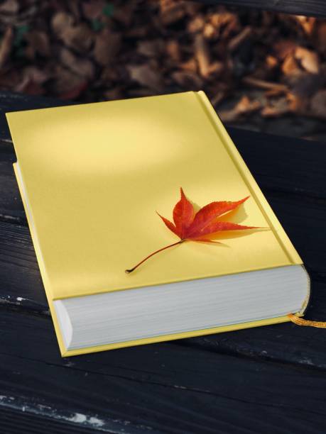 istock Yellow book and autumn maple leaves 1188303646