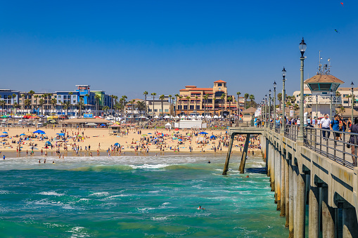 Huntington Beach, USA - July 03, 2017: View of the pier, Pacific Ocean and the beach in surf city Huntington Beach, famous tourist destination in California