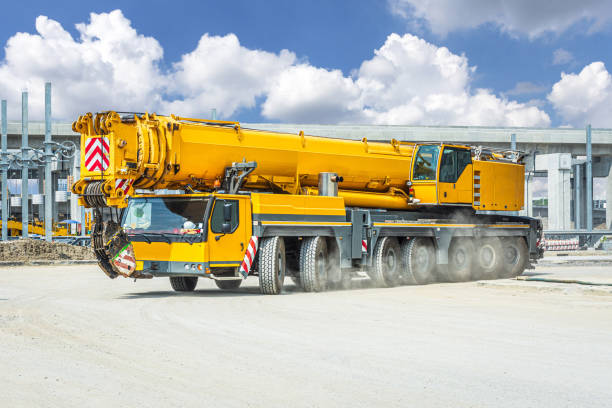 mobile crane against deep blue sky and white clouds.