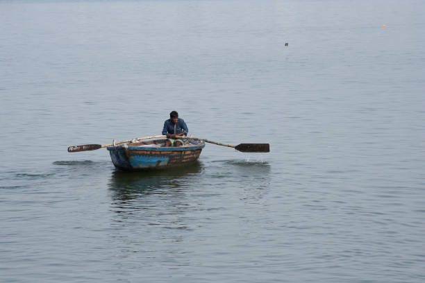моряк, пересекающий реку ганг в варанаси. - river men crossing spirituality стоковые фото и изображения
