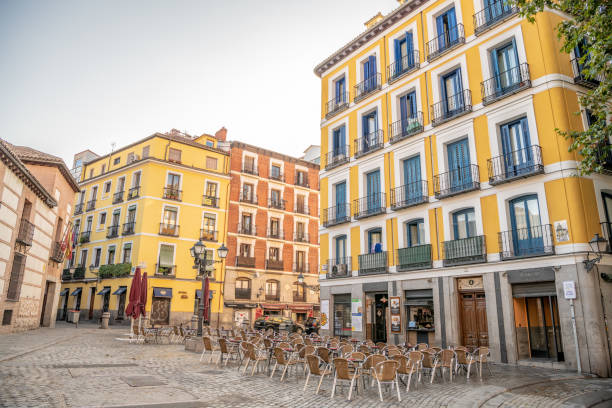 Chairs and tables set out on a plaza in the La Latina neighborhood in Madrid. stock photo