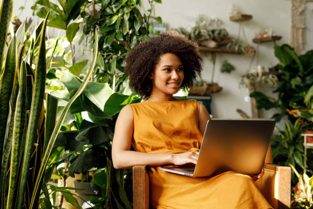istock Female botanist typing on laptop in her workshop looking away 1188326009