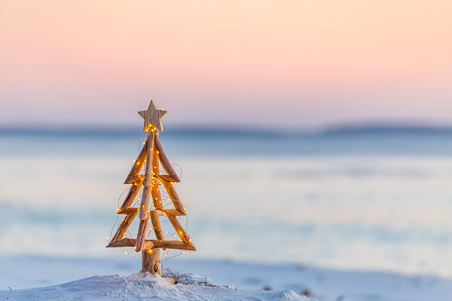 Coastal Christmas.  A Christmas tree with pretty fairy lights on the beach in Australia with soft background blur suitable for message