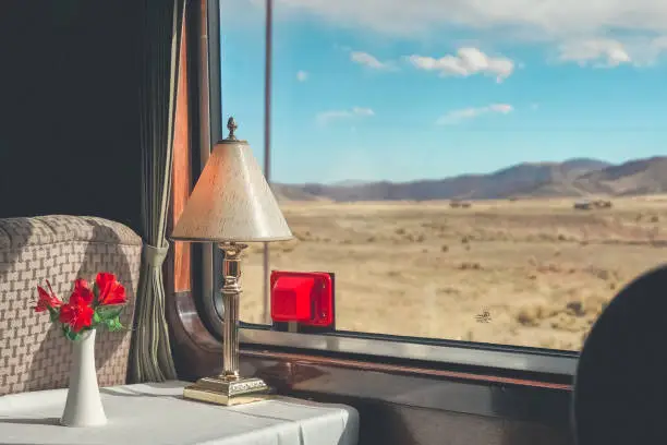 The luxury wooden decoration with comfortable sofas and fancy table lamps  of the Perurail Titicaca train. It is from Cusco across the Altiplano to Puno and Lake Titicaca in southern Peru.