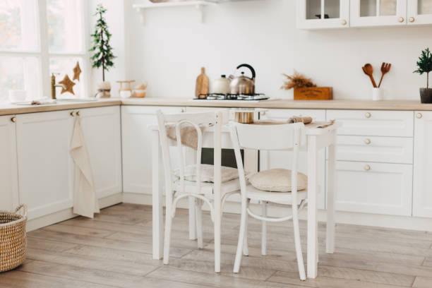 istock Modern new bright kitchen interior with white furniture and a dining table. 1188338658
