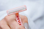 A lady's shaver in female hand. Close-up, selective focus.
