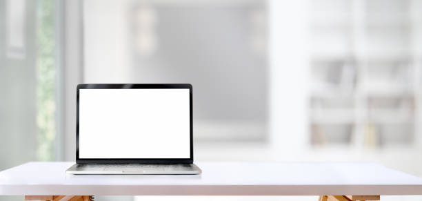 computadora portátil de pantalla en blanco sobre mesa de madera blanca con sala de estar en el fondo - encimera fotos fotografías e imágenes de stock