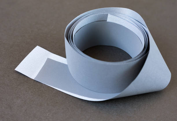 istock Gray clothing reflective tape. Close-up, selective focus. Highly reflective stripes for high visibility clothing in dark time. 1188340549