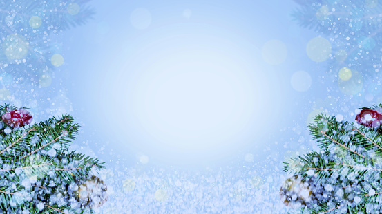 Christmas banner. Frosty snowy winter morning with fir branches, lights and snow. Copy space in the centre.