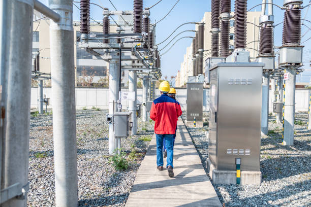 Power engineer checking electrical equipment at substation Power engineer checking electrical equipment at substation electricity substation photos stock pictures, royalty-free photos & images