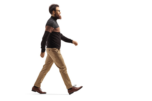 Hombre barbudo con gafas caminando photo