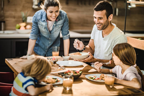 istock Happy family enjoying while having lunch in dining room. 1188343640