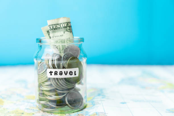 istock Saving money in a glass jar for travel on map 1188344901