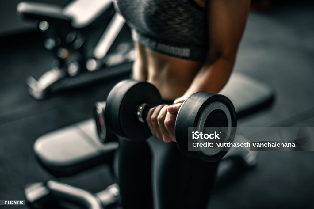 Bodybuilder working out with dumbbell weights at the gym. Gym Stock Photo