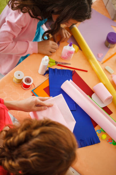 istock Mother and young daughter wrapping presents together 1188353914