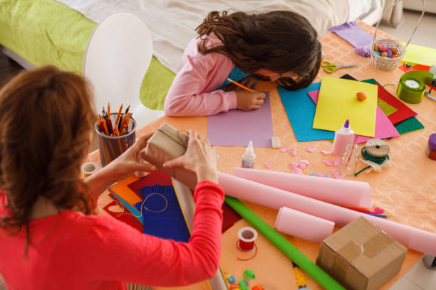 istock Mother and daughter wrapping presents and doing craft work at home 1188353920