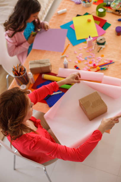 istock Mother and daughter wrapping presents and doing craft work at home 1188353922