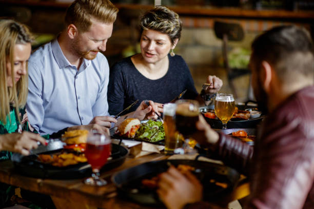 istock Friends talking and having lunch at the table in a pub 1188354543