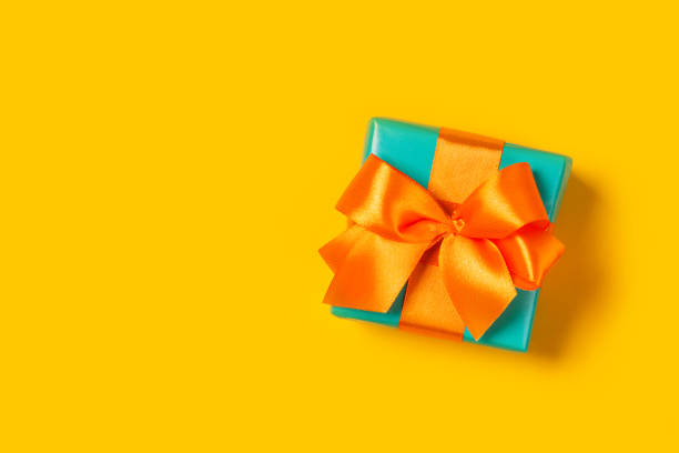 istock Stylish gift on a trendy orange background 1188356114