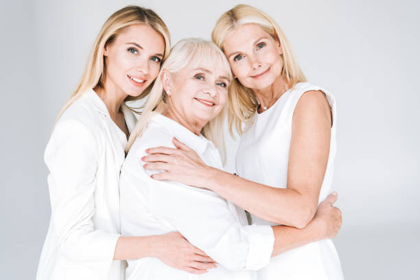 istock three generation blonde women embracing isolated on grey 1188356256