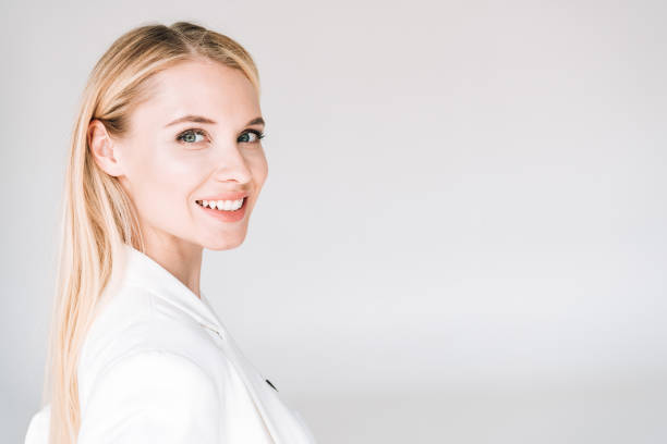 smiling beautiful young blonde woman isolated on grey