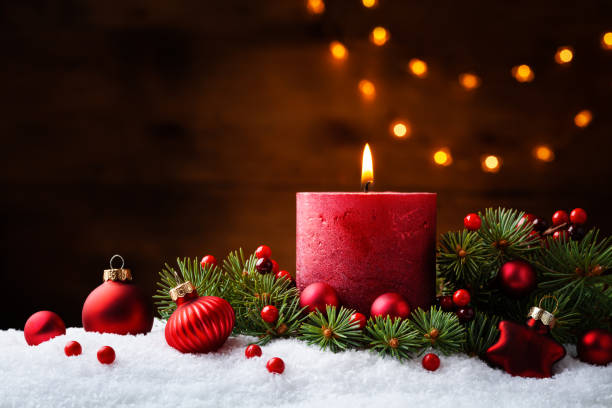 istock Advent candle, fir tree branches and holiday decorations in snow against light  garland background. Christmas card. 1188357706