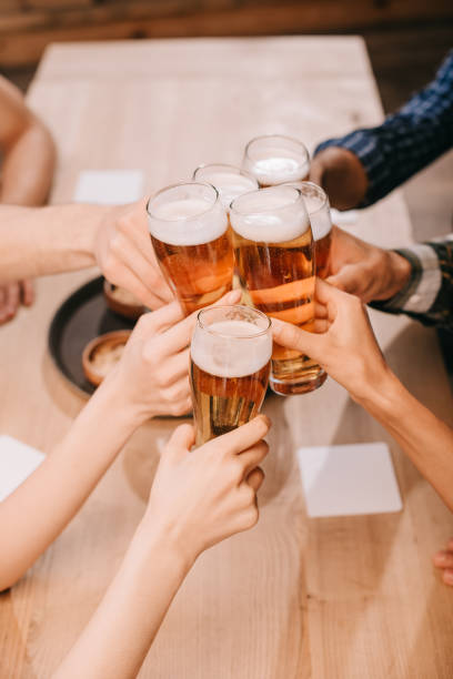 istock partial view of multicultural friends clinking glasses with lager beer in pub 1188363152