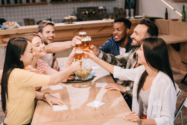 istock cheerful multicultural friends clinking glasses with beer while celebrating octoberfest in pub 1188363157