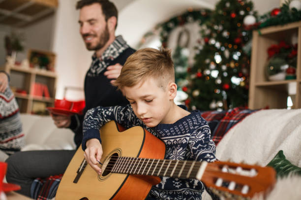 istock Little boy enjoying while playing the guitar 1188366277