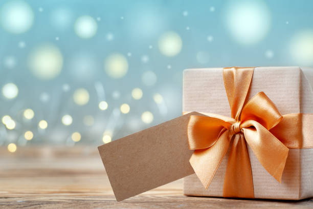 istock Gift box wrapped with craft paper and bow on neutral background with boke. Holiday concept. 1188366447