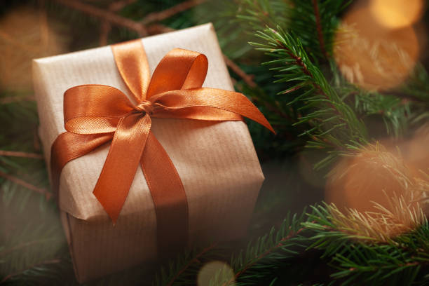 Christmas gift or present box wrapped craft on fir branches background. Christmas gift or present box wrapped craft on fir branches background with light bokeh n11 stock pictures, royalty-free photos & images
