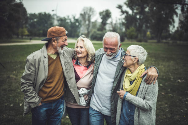 istock Happy seniors talking while walking embraced in nature. 1188370451