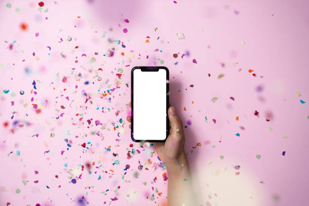Hands holding smart phone on pink background