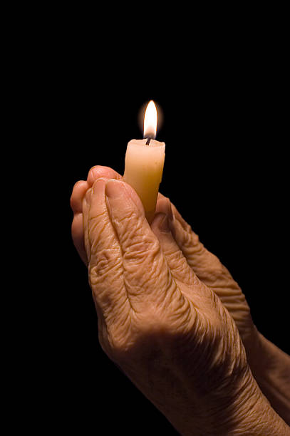 istock Old female hands with a candle 118837396