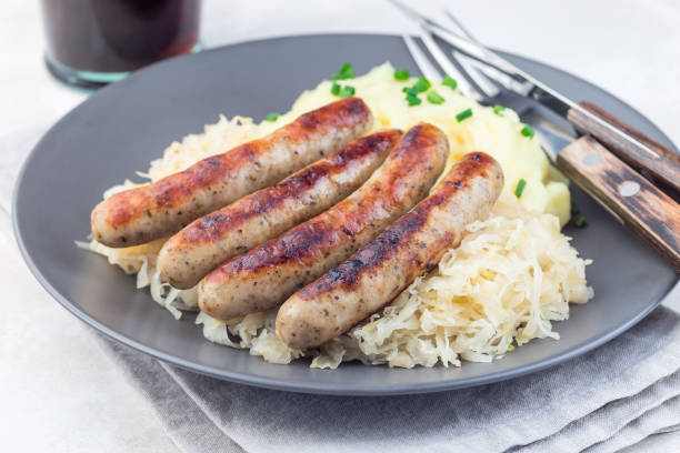istock Roasted nuremberg sausages served with sour cabbage and mashed potatoes, on  gray plate, horizontal 1188374029