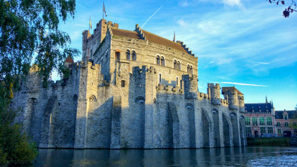 gravensteen (or castle of the counts), famous medieval monument in ghent, belgium, with lieve river around - castle gravensteen imagens e fotografias de stock