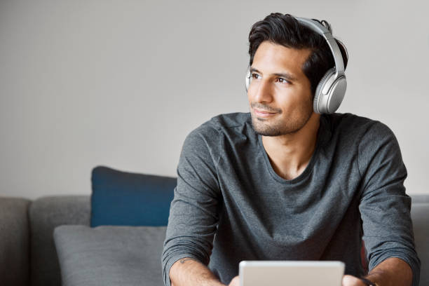 istock Thoughtful businessman with headphones looking away 1188375413