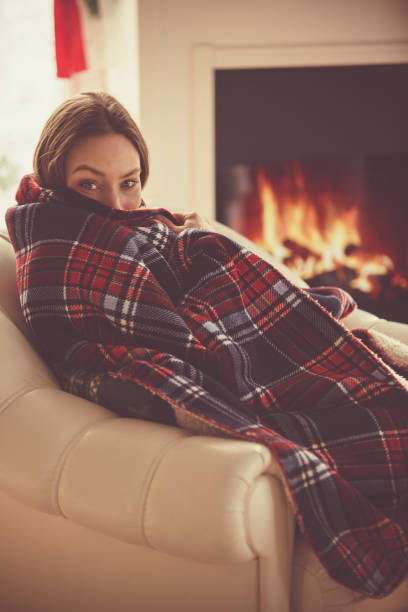 Young woman relaxing next to a fireplace