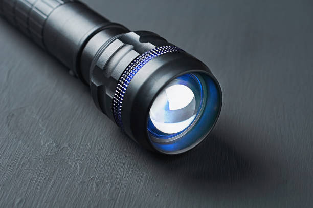 istock One black tactical flashlight lies on dark concrete table. Close-up 1188378020